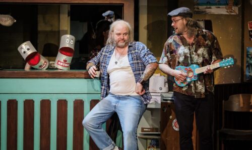 TIVOLI: „Die Königs schenken nach!“ - Uraufführung
Ein neues Musical von Martin Lingnau, Heiko Wohlgemuth und Mark Needham
Premiere im ‚Schmidt Theater’, am 02. Juni 2022.

Goldene Zeiten bei Familie König: Seit Oma bei der Glücksspirale die lebenslange Sofortrente gewonnen hat, ist im heimischen Souterrain der Wohlstand ausgebrochen. Wie seine vier Kinder ist auch Vater König, von allen nur Käpt’n genannt, voll im Kaufrausch und investiert erstmal in die heimische Wirtschaft. Also, wortwörtlich.
Volle Kasse, voller Kühlschrank und blau bis aufs Blut – kann das lange gutgehen bei unserer Lieblingssippe auf St. Pauli? Auf keinen Fall! Schnell zieht wieder das pralle Chaos ein und der Käpt’n und seine Sprösslinge wünschen sich sehnlichst die Sorgen von gestern zurück. Denn wo’s bisher nur ums schnöde Geld ging, geht’s jetzt ums nackte Überleben ...
Nach dem Erfolg von „Die Königs vom Kiez“ schicken Martin Lingnau und Heiko Wohlgemuth, Deutschlands erfolgreichste Musicalautoren, gemeinsam mit Co-Autor Mark Needham den daueralkoholisierten Käpt’n und seine Familienbande samt liebestoller Nachbarin Berta in ein neues schräges Abenteuer.
„Die Königs schenken nach!“ ist die nahtlose Fortsetzung der wahrscheinlich warmherzigsten Liebeserklärung an St. Pauli: mit liebgewonnenen Kieztypen, gnadenlosem Humor und mitreißenden Songs. Funktioniert auch ohne Vorwissen aus „Die Königs vom Kiez“. Die sollte man sich natürlich trotzdem nicht entgehen lassen.
Regie: Heiko Wohlgemuth, Buch & Musik: Martin Lingnau, Buch & Songtexte: Heiko Wohlgemuth, Buch: Mark Needham, Choreografie: Benjamin Zobrys, musikalische Leitung & Gesangsarrangements: Markus Voigt, Musikproduktion: Martin Lingnau, Joachim Schlueter Kostüm: Frank Kuder, Norman Heidrich, Viktoria Hase, Maske: Sophia May, Bühnenbild: Heiko de Boer, Requisite: Anja Majeski
„Die Königs schenken nach!“
Uraufführung: 2. Juni 2022 im Schmidt Theater
Weitere Termine: 3. Juni bis 31. Juli 2022
Di/Do 19.30 Uhr, Mi/So 19 Uhr, Fr/Sa 20 Uhr, nicht an Gastspieltagen Karten ab 25,30 € (zzgl. 2,- € Systemgebühr je Ticket)
Karten unter Telefon 040 / 31 77 88 99 und www.tivoli.de

Besetzung Pressekonferenz 24.5.2022: Marius Bingel, Götz Fuhrmann, Lisa Huk, Janice Rudelsberger, Veit Schäfermeier, Carolin Spieß, Benjamin Zobrys.

Mehr Infos zu Kreativteam und Ensemble auf tivoli.de

Photo: Morris Mac Matzen/mmacm.com für TIVOLI
###Verwendung honorarfrei im Zusammenhang mit redaktioneller Berichterstattung zu -  „Die Königs schenken nach“ im ‚Schmidt Theater’ - Hamburg.###